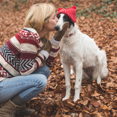 Young blonde woman embraced and kissing her cute Borzoi dog outdoor