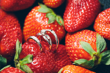 wedding rings on a red strawberry