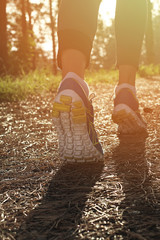 Athlete runner feet running in nature, closeup on shoe. Woman fitness jogging, active lifestyle...