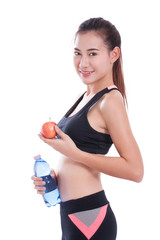 Fitness young woman holding a bottle of water and an apple over white background