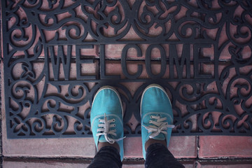 Selfie of sneakers with welcome doormat