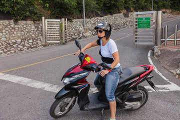 Woman on a scooter with helmet and sunglasses