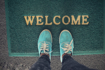 Selfie of sneakers with welcome doormat