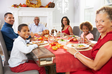 Family With Grandparents Enjoying Thanksgiving Meal At Table