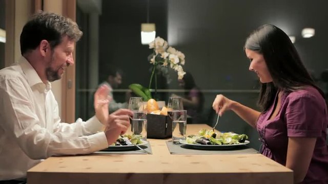 Happy couple having beautiful romantic dinner with wine at home at night