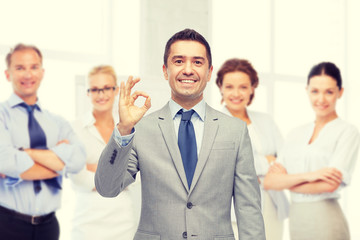 happy businessman in suit showing ok hand sign