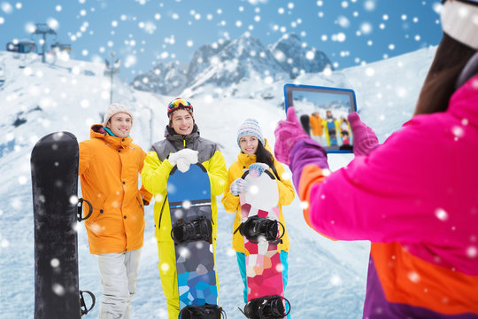 happy friends with snowboards and tablet pc