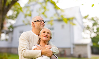 senior couple hugging over living house background