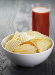 rippled organic chips in white bowl wit tomato juice