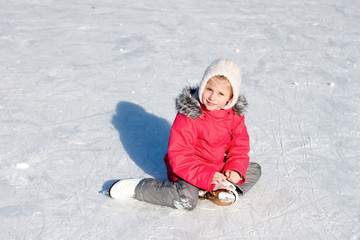Fototapeta na wymiar Little girl learning to ice-skate. Winter fun.
