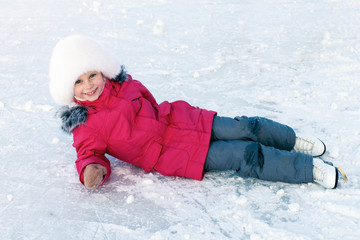 Fototapeta na wymiar Little girl learning to ice-skate. Winter fun.