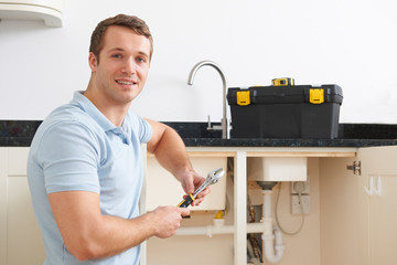 Portrait Of Plumber Fixing Sink