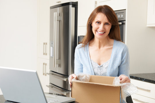 Woman Unpacking Online Purchase At Home