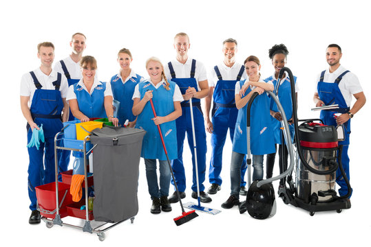 Portrait Of Happy Janitors With Cleaning Equipment
