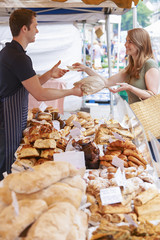 Woman Buying Bread From Market Stall