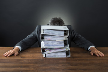 Frustrated Businessman With Lot Of Files On Desk