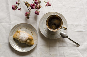 Черный кофе и булочка с пудрой