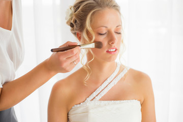 Beautiful bride getting her makeup fixed