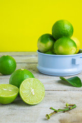 green lemon on wood table with yellow background