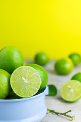 green lemon on wood table with yellow background