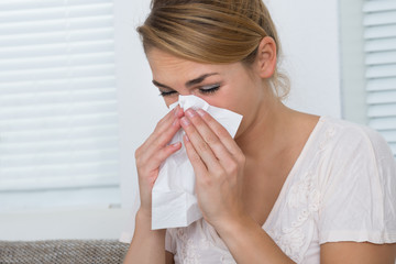 Woman Blowing Nose While Suffering From Cold