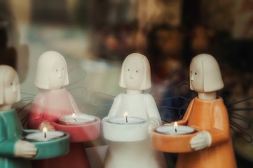 four figures of angels with candles