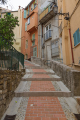 Fototapeta premium downtown Menton in France, the old narrow streets with colored buildings, windows and doors. Cote d'Azur.