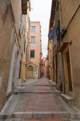 Fototapeta na wymiar downtown Menton in France, the old narrow streets with colored buildings, windows and doors. Cote d'Azur.