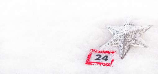 Kalenderdatum 24. Dezember im Schnee mit Weihnachtsstern