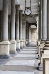 Old clock, and stone columns in Karlovy Vary, Czech Republic
