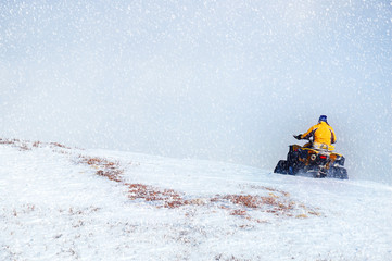 Man driving snowmobile in winter mountain. Beautifull snowfall