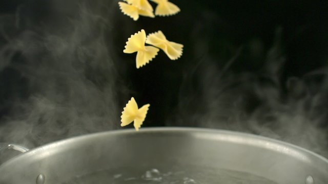 Throwing farfalle pasta into boiled water in pot shooting with high speed camera, phantom flex.