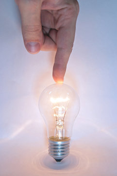 Human hand points a finger at the lamp