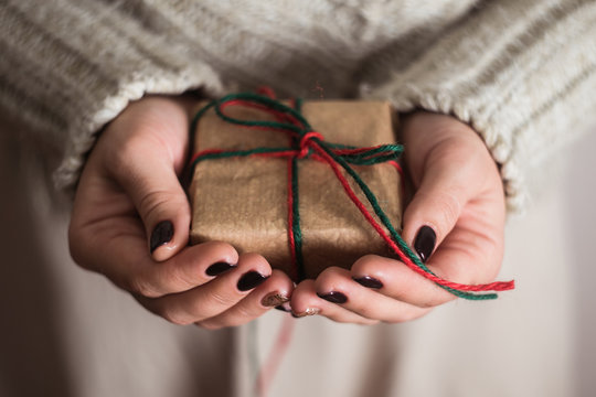 girl holding a gift box. Manicure gel nail