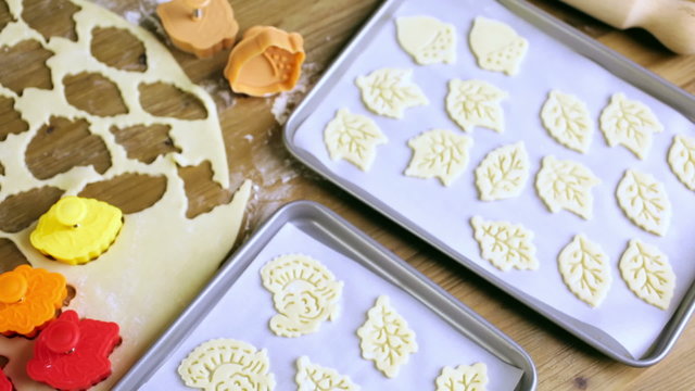 Cutting out Autumn leafs with cookie stamper to decorate pumpkin pie