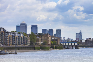 London Canary Wharf Docklands office buildings view over Thames river and wharf houses, on cloudy summer day