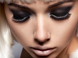 The girl's face closeup with long black lashes. fashion makeup