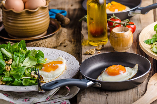 Fried eggs with salad and nuts