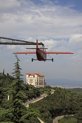 Fototapeta premium BARCELONA, CATALONIA, SPAIN - AUGUST 29, 2012: Red aeroplane and Gran Hotel La Florida near Tibidabo, Barcelona,Catalonia, Spain