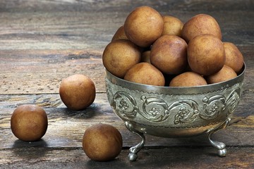 Lübecker Marzipankartoffeln in einer Silberschale auf Holzhintergrund