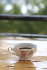 Coffee in a small vintage porcelain cup, on a terrace. Selective focus.