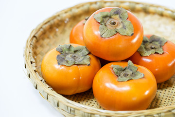 Fresh ripe persimmons on Japanese bamboo basket