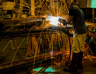 worker with protective mask welding metal