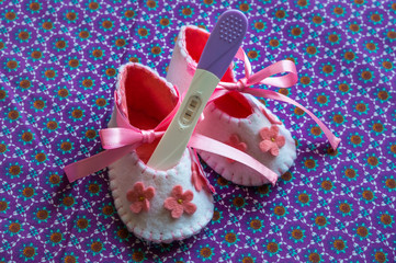 Newborn baby girl booties and pregnancy test