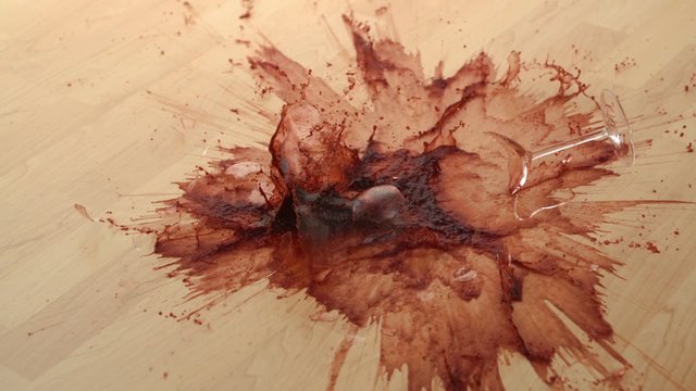 Dropping glass of red wine and breaking on wooden floor shooting with high speed camera, phantom flex.