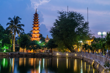 Lights of Tran Quoc Pagoda reflected in lake by night,  Hanoi