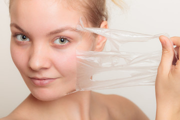 girl removing facial peel off mask