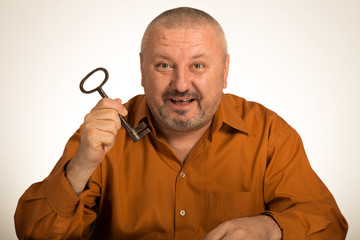 A man holding a key to success looking amazed