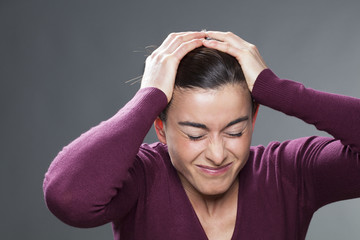 disappointment concept - shocked 30s woman creasing her eyes and covering her head with hands for regret and confusion,studio shot