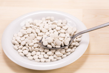 皿の上からスプーンですくった錠剤